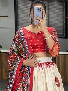 Elevate your ethnic wardrobe with our stunning "adorable off-white & red patola printed silk festival wear lehenga choli." Crafted from high-quality dola silk material in off-white and red colors, this traditional ensemble is adorned with intricate patola and paithni printed work, along with shimmering foil work (crush work) that adds a touch of glamour to the outfit.
This lehenga choli set include a lehenga stitched up to 42 inches with a 3.8-meter flair, a 41-inch lehenga length, and an un Festive Red Bandhani Print Lehenga, Red Bandhani Print Lehenga For Navratri, Red Fitted Bandhani Print Lehenga, Fitted Red Bandhani Lehenga, Red Fitted Bandhani Lehenga, Festive White Unstitched Choli Blouse, Festive White Unstitched Choli, Festive White Ikat Print Saree, Red Anarkali Choli With Bandhani Print