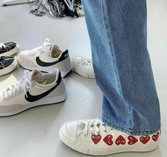 four pairs of shoes with hearts painted on them are sitting next to each other in a row