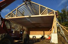 a house under construction with a crane on it's back and the roof being built