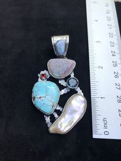 "Artisan Turquoise gemstone Pendant Hand-made Sterling Silver 925. Stones used: Rainbow Druzy, Turquoise, Australian Opal, Pearl, London Blue Topaz, Garnet Height - 3\" (with bail), Width - 1 5/8\" Height -75mm (with bail), Width - 40mm Unique Handcrafted One-of a-kind Design Each Piece of Jewelry in my Collection is Absolutely One of a Kind! When you start wearing a piece of my jewelry you will fall in love with it more and more each day and feel that good Energy and Love that I pass into it wh Artisan Blue Multi-stone Turquoise Necklace, Artisan Blue Turquoise Multi-stone Necklace, Artisan Multi-stone Turquoise Necklace, Collectible Blue Turquoise Gemstone Necklace, Elegant Multi-stone Turquoise Gemstones, Artisan Jewelry With Gemstone Accents For Anniversary, Turquoise Multi-stone Round Gemstones, Turquoise Multi-stone Gemstones, Anniversary Natural Stones Gemstones