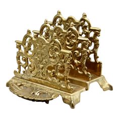 an ornately designed gold bookend stands against a white background