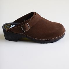 Clogs in brown suede leather with a classic strap over the ankle and a black wooden platform.  SIZE: EU 37 heel height - 4,5 cm / front platform - 3 cm  era: 2000s / y2k   content: suede leather, wood  condition: new without original box (new used) brand: Rega  Made in Poland Processing 1-2 business days.    - Fast free shipping via Global Express to the United States, Canada, Australia, Austria, Belgium, China, Czech Republic, Denmark, Estonia, Finland, Germany, Greece, Hungary, Ireland, Israel Suede Clogs With Buckle Closure And Round Toe, Closed Toe Suede Clogs With Buckle Closure, Suede Closed Toe Clogs With Buckle Closure, Classic Suede Clogs With Buckle Closure, Vintage Brown Mules With Leather Footbed, Brown Leather Mules With Suede Lining, Vintage Brown Mules With Leather Sole, Brown Suede Clogs With Rubber Sole, Leather Clogs With Suede Lining And Round Toe