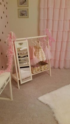 a room with pink curtains and shoes on the shelf in front of it, next to a white bench