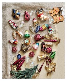 an assortment of christmas ornaments on a linen tablecloth, with one ornament in the middle