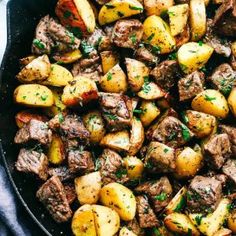 a skillet filled with potatoes and meat