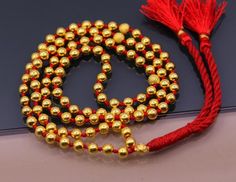 A Japamala or mala is a string of prayer beads commonly used in Hinduism, Jainism, Sikhism, Buddhism and Shintō for the spiritual practice known in Sanskrit as japa. The rosary is usually made from 108 beads, though other numbers are also used. Malas are used for keeping count while reciting, chanting, or mentally repeating a mantra or the name or names of a Deity.20karat gold beads strung in a cotton thread with knot within each gold beads to make this necklace.Metal-20karat yellow gold.Type- N Gold Jewelry With Hand-knotted Round Beads, Gold Hand-knotted Necklace For Gift, Gold Hand Knotted Necklace For Gift, Mala With 8mm Beads As Festival Gift, Adjustable Gold Mala With 8mm Beads, 8mm Beaded Mala For Festivals And Gifts, Spiritual Round Beads Mala For Puja, Spiritual Mala With Round Beads For Puja, Spiritual Mala For Puja With Round Beads