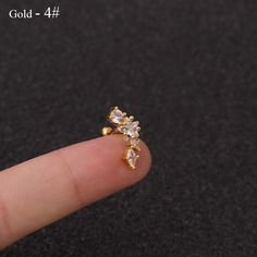 a person's finger with a tiny gold ring on top of their thumb,