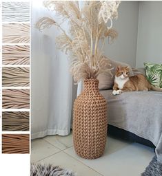 a cat sitting on a bed next to a vase