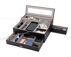 an open black box containing various items and a cell phone on it's side