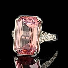 a fancy pink diamond ring with diamonds around it