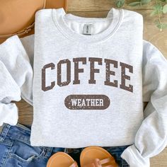 Get cozy this season with our retro-inspired "Coffee Weather" Sweatshirt and Hoodie! Featuring a stylish vintage design, this comfy apparel is perfect for those chilly days when all you need is a warm cup of coffee. Whether you're lounging at home, heading out for a coffee run, or enjoying a brisk walk, this sweatshirt or hoodie adds a touch of retro flair to your wardrobe. Key Features: -Retro Design: The phrase "Coffee Weather" is displayed in a bold, vintage-inspired font, perfect for coffee Coffee Letter Print Tops For Fall, Coffee Colored Tops With Letter Print For Fall, Coffee Colored Cotton Sweatshirt With Letter Print, Coffee-colored Graphic Print Sweatshirt For Fall, Fall Coffee Cotton Sweatshirt, Coffee-colored Relaxed Fit Sweatshirt With Letter Print, Coffee Cotton Sweatshirt For Fall, Coffee Colored Relaxed Fit Sweatshirt With Letter Print, Fall Cotton Coffee Sweatshirt