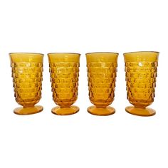 four yellow glass cups sitting on top of each other