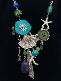 Dive into the beauty of the ocean with our Aquatic Treasures Charm Chain Necklace! Featuring a delicate chain adorned with vibrant charms inspired by sea life, this necklace will add a touch of whimsy and elegance to any outfit. Make a splash and express your love for the ocean with this one-of-a-kind accessory! Bohemian Blue Starfish Charm Jewelry, Bohemian Blue Jewelry With Starfish Charm, Ocean-inspired Metal Jewelry, Blue Charm Necklaces For The Beach, Handmade Mermaid-shaped Ocean-inspired Necklaces, Ocean-inspired Charms For Jewelry Making, Adjustable Ocean-inspired Necklace With Starfish Charm, Ocean-inspired Turquoise Necklace With Starfish Charm, Turquoise Ocean-inspired Necklace With Starfish Charm