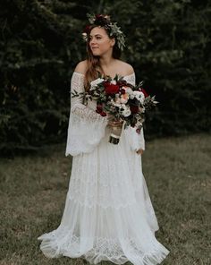 a woman in a white dress holding flowers and wearing a flower crown on her head