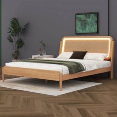 a bed sitting on top of a wooden floor next to a green plant in a bedroom