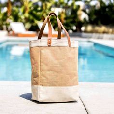 a canvas tote bag sitting next to a swimming pool