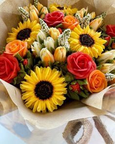 a bouquet of sunflowers and roses on a table