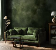 a green couch sitting in front of a window next to a table with a lamp on it