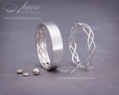 two silver rings sitting next to each other on top of a gray surface with small beads