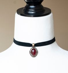 This Victorian inspired choker is made from black velvet ribbon and antique bronze filigree pendant housing a dark red glass cabochon. - The choker measures 12 inches/30.5cm in length and 0.4 inches/10mm wide - The pendant is approximately 1 inch long and 0.75 inch wide - The choker closes with a lobster claw clasp at the back - One size fits most (for a neck of about 12.5 inches). there is a 2 inch extension chain at the back to accommodate larger neck sizes SHIPPING: Default shipping is by reg Black Choker With Pendant, Red Acssesories Aesthetic, Gothic Pendant Necklace, Black Vintage Jewelry, Vintage Red Choker For Party, Red Adjustable Classic Jewelry, Vintage Red Choker Jewelry, Red Vintage Choker Jewelry, Victorian Red Jewelry With Vintage Charm