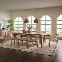 a dining room table surrounded by chairs and windows