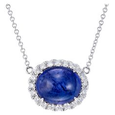 Vivid blue earth mined tanzanite and diamond pendant necklace. 8.00 carat oval cabochon center stone with blue and purple overtones surrounded a brilliant cut diamond halo. 18 inch 18k white gold chain. Created in the Peter Suchy Workshop 1 oval cabochon blue tanzanite, MI approx. 8.00cts 20 round brilliant cut diamonds, F-G VS, approx. .40cts 18k white gold Stamped: 18k 750 5.9 grams Top to bottom: 13.2mm or .5 Inch Width: 15.8mm or 5/8 Inch Depth or thickness: 9.8mm Chain: 18 Inches Total leng Round Pendant Necklace 1stdibs, Fine Jewelry Cabochon Gemstones For Formal Occasions, Formal Fine Jewelry Cabochon Gemstones, Exquisite Formal Gemstone Cabochons, Formal Round Gemstone Cabochons, Formal Fine Jewelry Gemstone Cabochons, Formal Cabochon Round Gemstone, Exquisite Tanzanite White Gold Jewelry, Timeless White Gold Jewelry With Cabochon