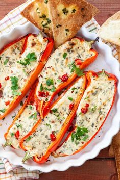 cheese stuffed peppers on a plate with crackers