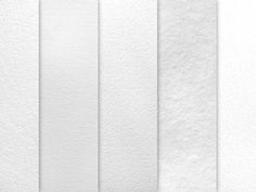 four white paper strips lined up on top of each other in different sizes and colors