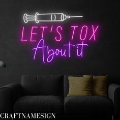 a neon sign that says let's toy about it in front of a couch