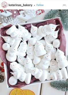 a box filled with white plastic snowmen sitting on top of a table next to orange slices