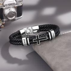 Introducing our latest collection: the Custom Family Name Black Leather Bracelet. It is a perfect blend of style, personalization, and faith. Crafted with genuine black leather, this bracelet is not just a fashion accessory, but also a symbol of love, unity, and devotion. 1. Personalized Leather Men Bracelet: This exquisite piece can be customized with 2-4 names or initials of your choice. It adds a personal touch to the bracelet, making it a unique and meaningful gift. Carry the names of your l Black Metal Wrap Bracelet For Gift, Black Engraved Bracelets For Friendship, Black Engraved Wristband Bracelet, Personalized Black Leather Bracelet With Stainless Steel, Black Engraved Wristband For Friendship, Metal Bracelet With Black Band As Gift, Black Stainless Steel Friendship Bracelets, Adjustable Black Cross Bracelet, Black Cross Bracelet As Gift