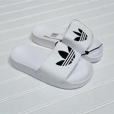 Nwt Adidas Adilette Lite Slides/Sandals, Size 3 Big Kid, White With Black Logo, White Synthetic Slip-on Slippers, Comfortable White Slip-on Sandals, Casual White Slip-on Flip Flops, Adidas Slides With Rubber Sole For Summer, Adidas Casual Sport Sandals For Summer, White Non-slip Slippers For Vacation, White Rubber Sole Flip Flops For Spring, Trendy White Round Toe Sandals, White Synthetic Sandals For The Beach