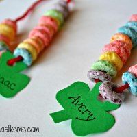 two bracelets made out of candy beads and green shamrock charms on a table with st patrick's day decorations