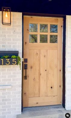 the front door is made of wood and has a planter on it's side