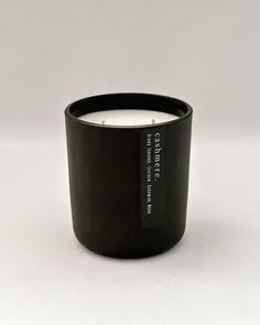 a black candle sitting on top of a white table