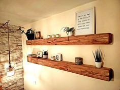 two wooden shelves with plants and candles on them