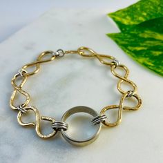 "After receiving quite a bit of interest in the bracelet I created to house my late husband's wedding band so that I could wear it daily, I decided to start offering this option to those of you who wish to do the same! Thick wire is hand molded into infinity links and hammered to catch the light and give this beautiful bracelet some depth.  Your loved one's band will be securely linked into the center of the bracelet. Note: I can only use bands in this style of bracelet.  If they have stones, th Adjustable Heirloom Bracelets For Anniversary, 14k Stamped Bangle Bracelet For Anniversary, White Gold Bracelet As Gift, Gold Bracelet With Decorative Band For Anniversary, Gold Sterling Silver Engraved Bracelet For Wedding, Gold Bracelet With Polished Finish For Anniversary, Modern Jewelry With Decorative Band For Anniversary, Round Gold Bracelet With Polished Finish For Anniversary, Anniversary Bangle Bracelet With Decorative Band