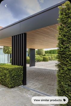 an entrance to a building with hedges and trees