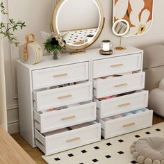 a white dresser with lots of drawers and a mirror on the wall above it in a room