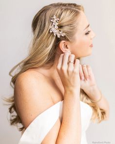 a woman in a white dress with her hand on her shoulder