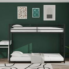 a bunk bed sitting next to a white desk and chair in a room with green walls