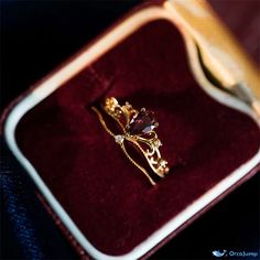 a gold ring sitting on top of a velvet box