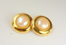 Beautiful vintage signed Monet gold round faux pearl clip-on earrings. It measures approximately 1 3/8" in diameter, 0.5" thick and one earring weighs 0.7 oz.  It is Estate item in excellent condition, there is no wear to the gold and the clasp works very well. We combine shipping.  Thank You for visiting our Etsy https://www.etsy.com/shop/VictoryIssweet store! Gold Round Clip-on Pearl Earrings, Gold Clip-on Round Pearl Earrings, Formal Round Metal Clip-on Earrings, Retro Gold Round Clip-on Earrings, Retro Round Gold Clip-on Earrings, Retro Round Clip-on Earrings For Formal Occasions, Monet Earrings, Monet Jewelry, Vintage Signs