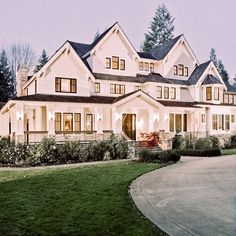 a large white house sitting on top of a lush green field