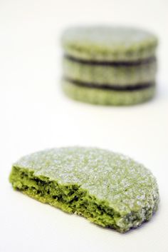 green cookies with powdered sugar on the top and one cookie in the middle, sitting next to each other