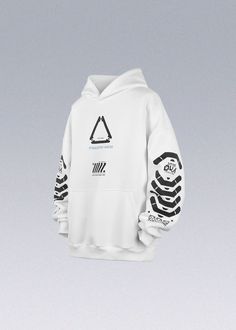 a white hoodie with black and white designs on the sleeves hanging in front of a gray background