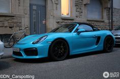 a blue sports car parked in front of a building