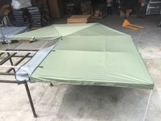 a green tent sitting on top of a metal frame