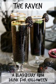 two glasses filled with blackberry rum drink on top of a table next to halloween decorations