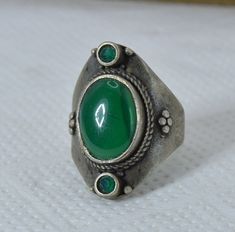 Handmade Tuareg Moroccan Silver African Berber Ethnic Ring with Green Stone - Ancient Vintage bague, Unique Gift Onyx Carnelian This exquisite vintage ring is crafted from silver, showcasing a beautifully polished green gemstone at its center. The oval-shaped stone is set within an ornate silver band, adorned with intricate detailing that reflects African Berber ethnic artistry. Smaller green stones accentuate the design, adding a harmonious and eye-catching touch. The silver band features delic Handmade Green Bohemian Ring, Traditional Green Rings, Traditional Green Toe Ring, Traditional Handmade Green Rings, Bohemian Green Toe Rings, Traditional Oval Rings For Jewelry Making, Ring With Green Stone, Ring Green Stone, Silver Work